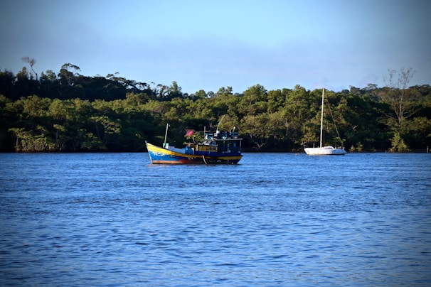 A vibrant fishing boat cutting through the calm blue sea at sunrise near Unawatuna.
