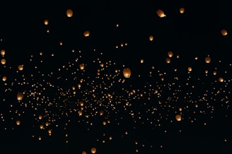 floating paper lanterns on sky during nighttime