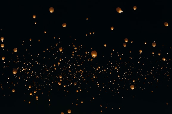 floating paper lanterns on sky during nighttime