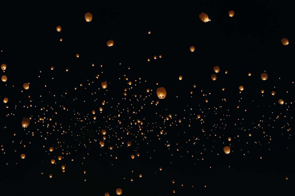 Linternas de papel flotantes en el cielo durante la noche