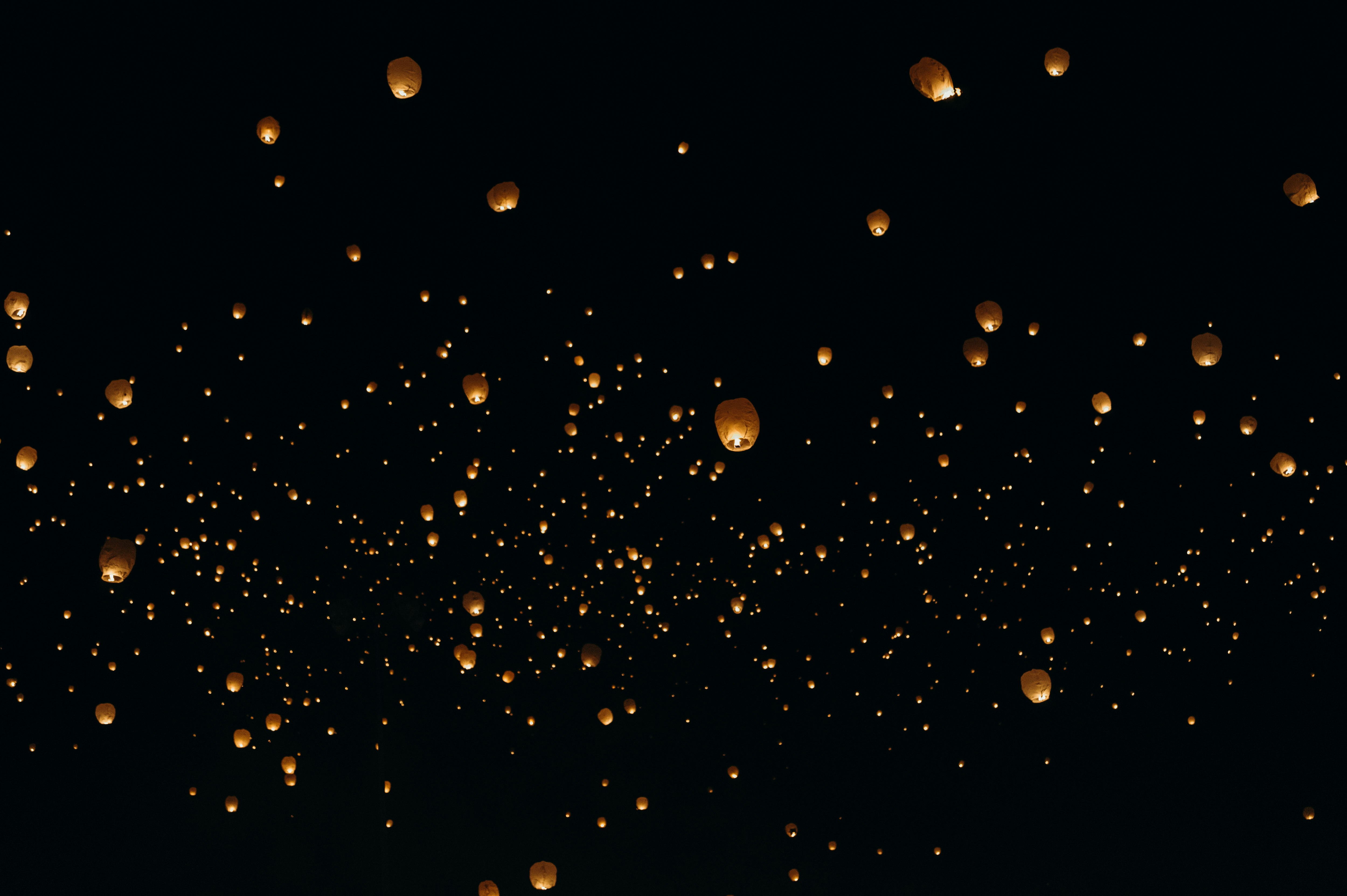 floating paper lanterns on sky during nighttime