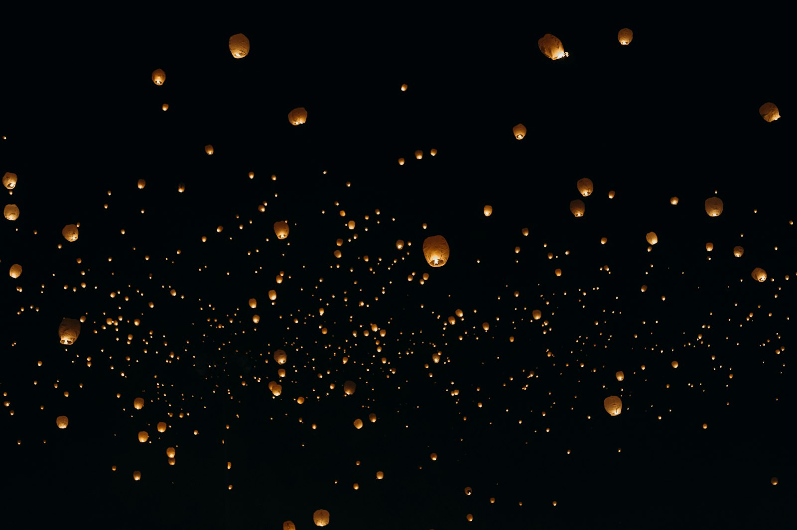 Paper lanterns floating in the night sky