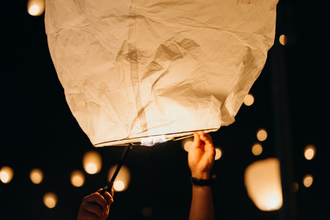 white paper lantern flying at nighttime