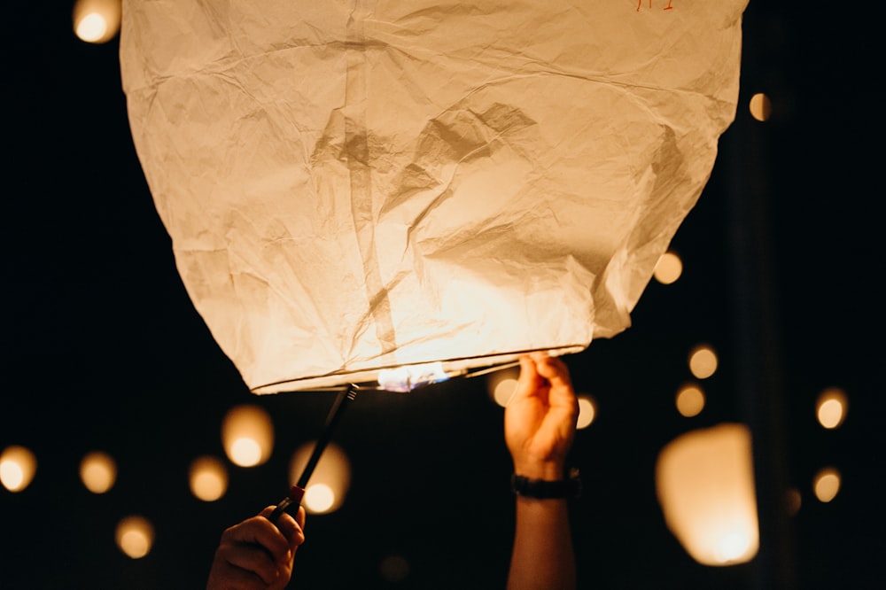 white paper lantern flying at nighttime