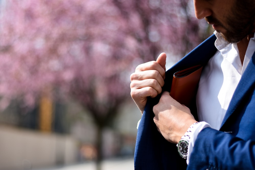 man putting wallet on suit pocket