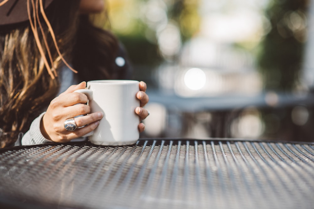 person holding white ceramic mug