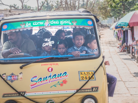 A cheerful school coach with children boarding safely under the watchful eye of a DBS-checked driver.