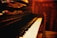 A close-up photo of a vintage Blüthner grand piano keyboard with warm lighting.
