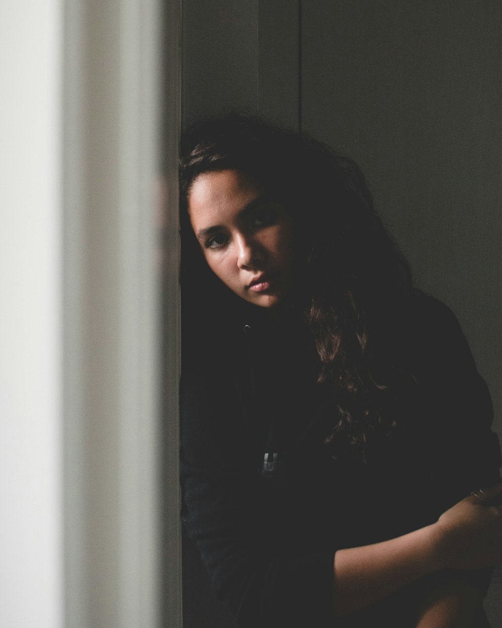 standing woman leaning on wall