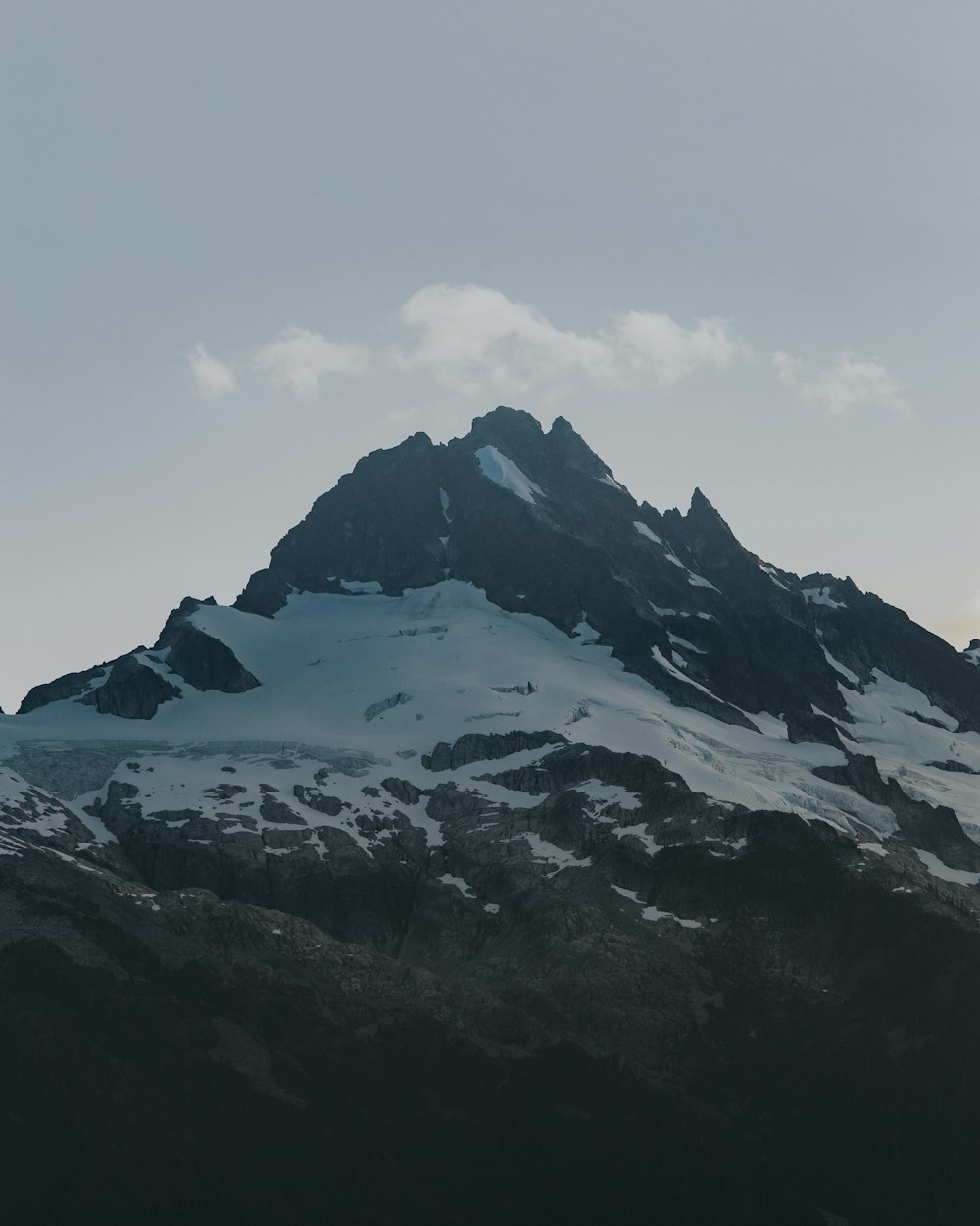 snow covered mountain under white clouds