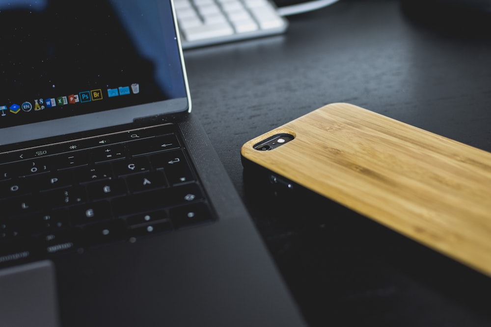 brown wood-style iPhone case near laptop computer