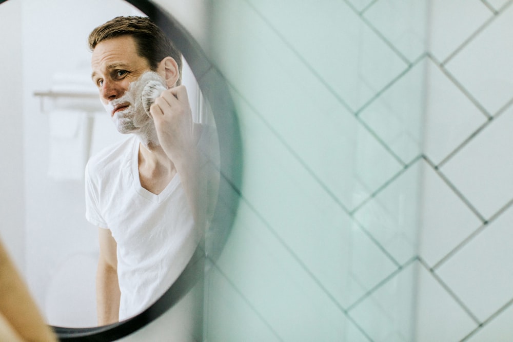 man shaving in front of mirror