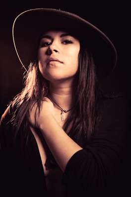 Soft-focus image of a smiling woman wearing a statement necklace, radiating confidence.