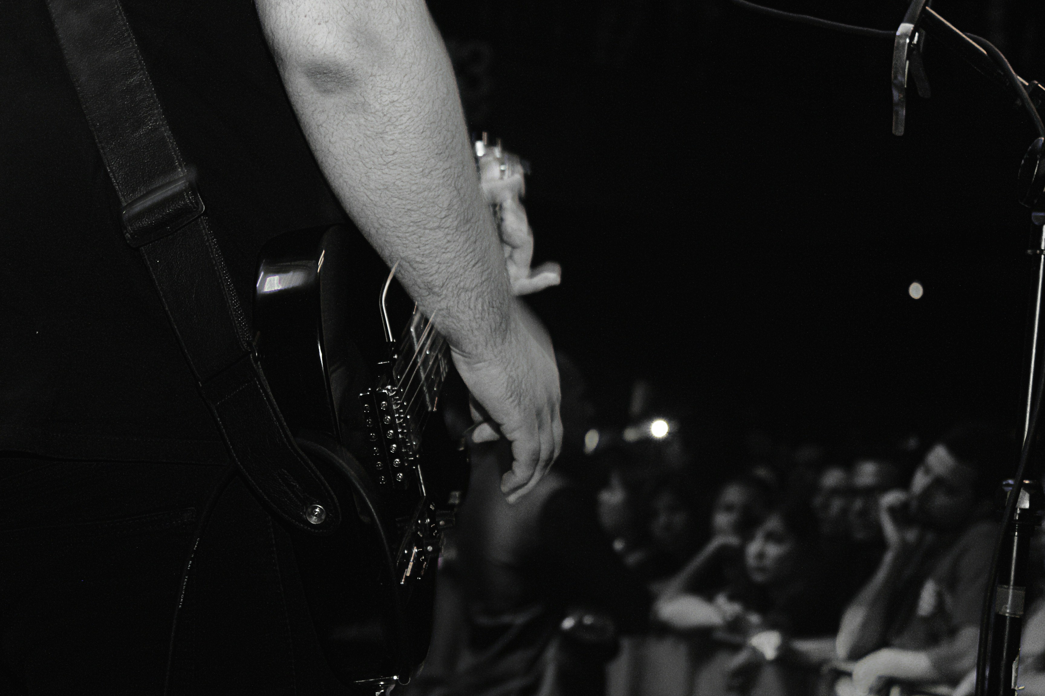 grayscale photo of person playing guitar