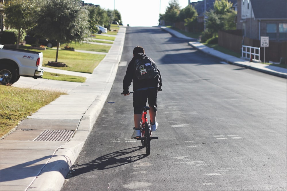 Hombre en bicicleta a lo largo de la carretera asfaltada durante el día