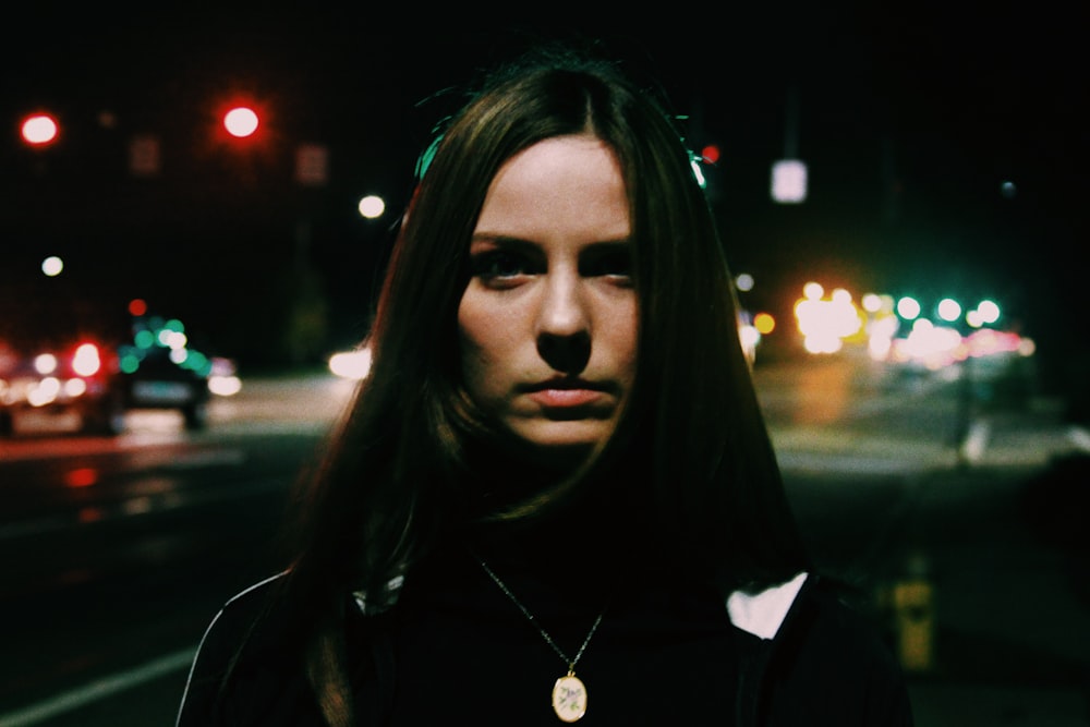 woman standing near city road during nighttime