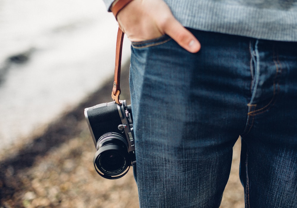 person holding black and gray DSLR camera