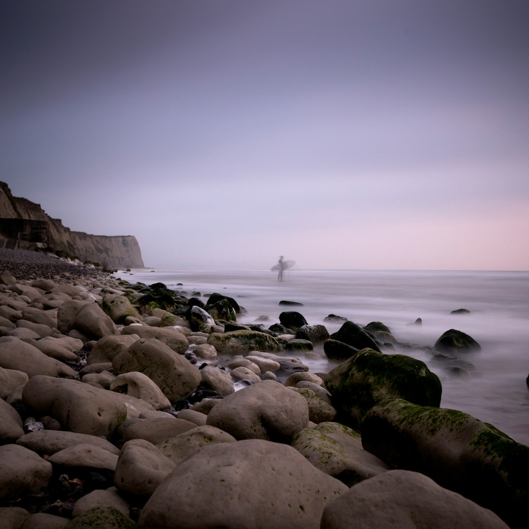 surfer standing on seashore