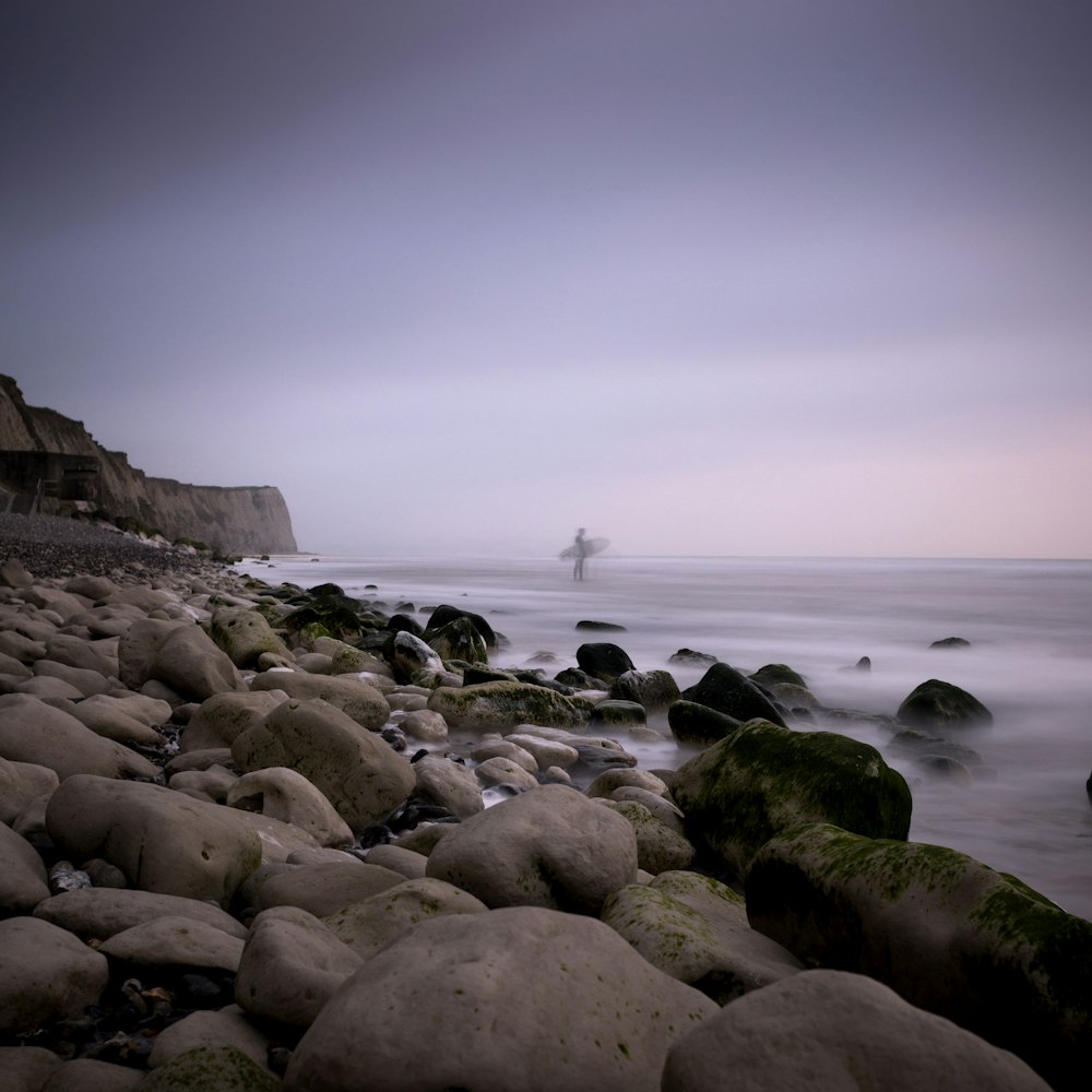 surfer standing on seashore