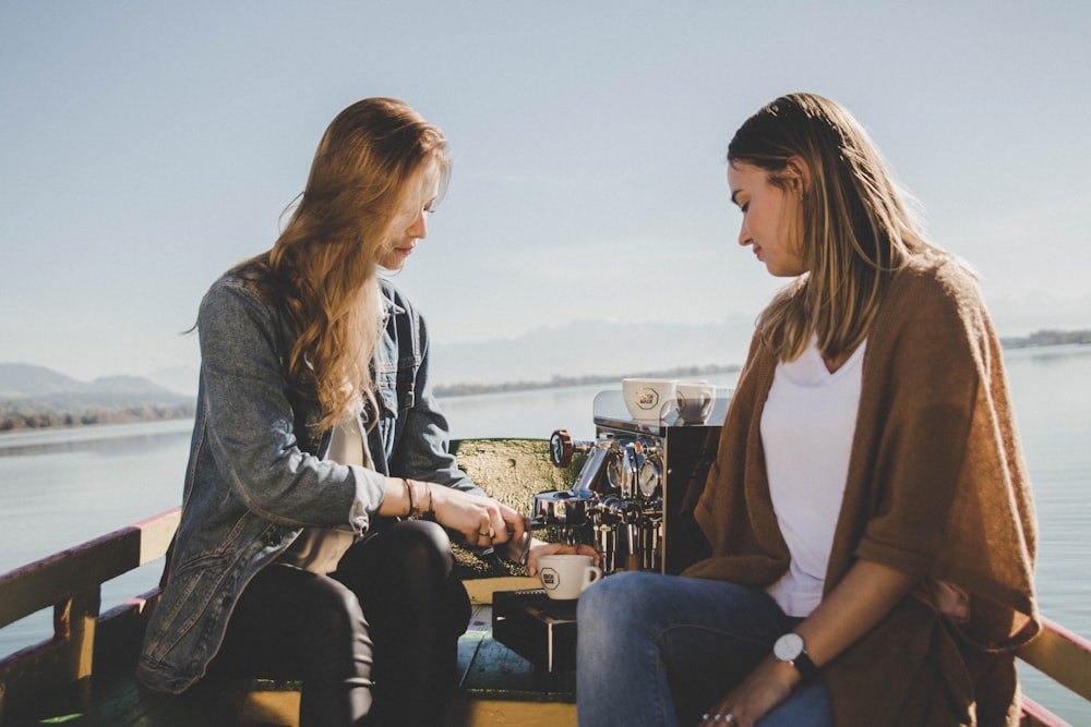 two women on boat with espresso machine at sea