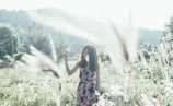 Wide shot of a serene Bavarian meadow with a model dressed in esterl leisurewear, blending into nature.