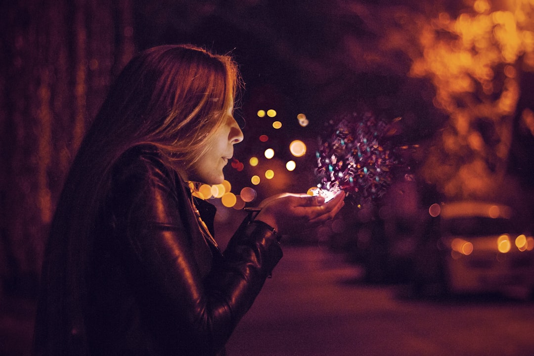 woman blowing sprinkle in her hand,