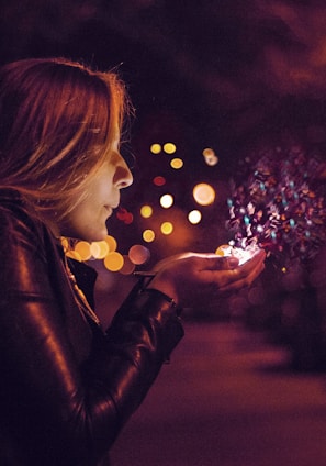 woman blowing sprinkle in her hand