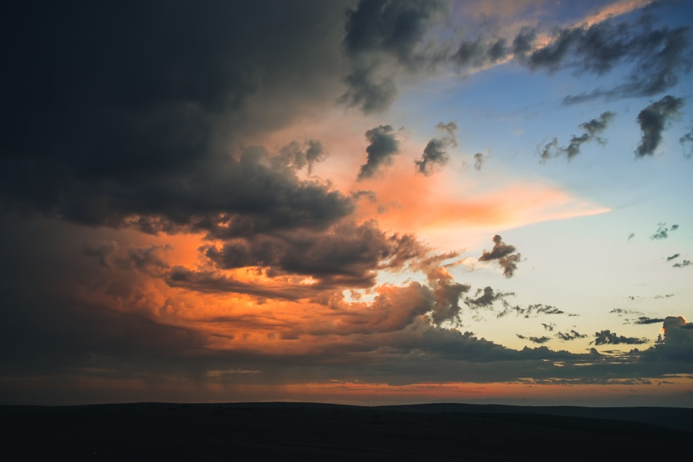 Photographie de nuages blancs et noirs au coucher du soleil