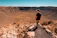 man wearing black shirt standing on rock formation during daytime