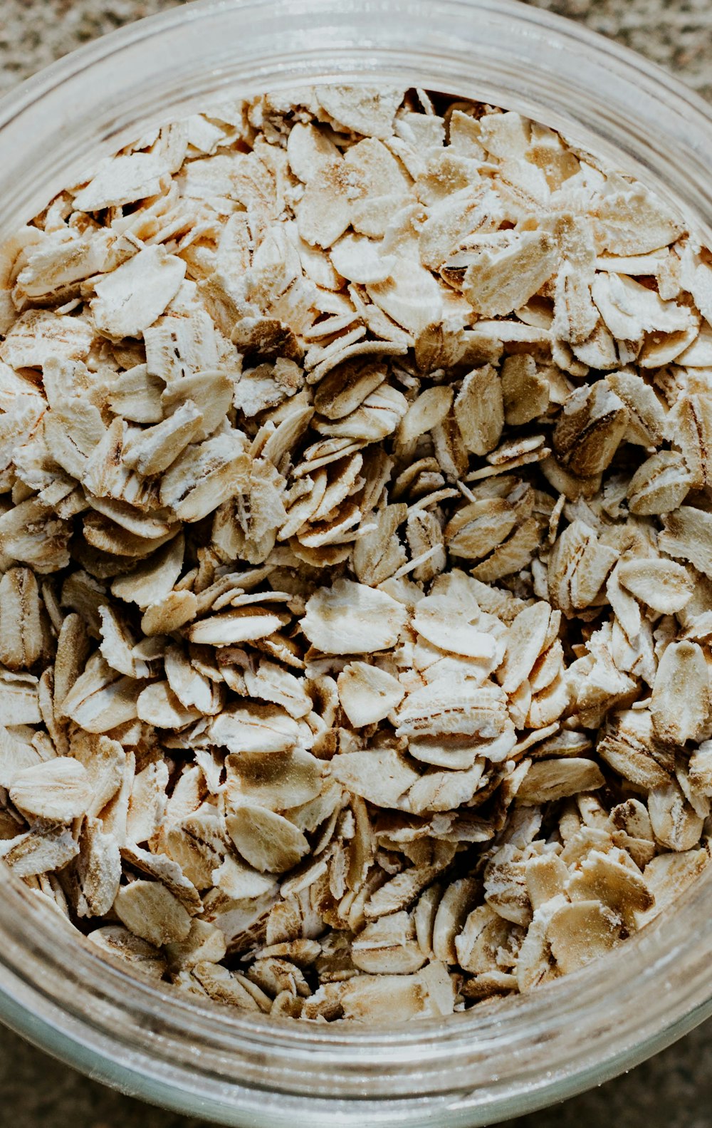 un tazón de vidrio lleno de avena encima de una mesa