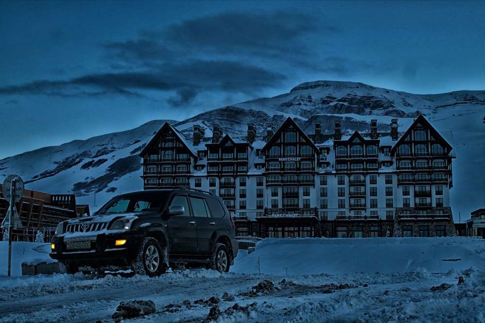 SUV parked in front building with mountain background