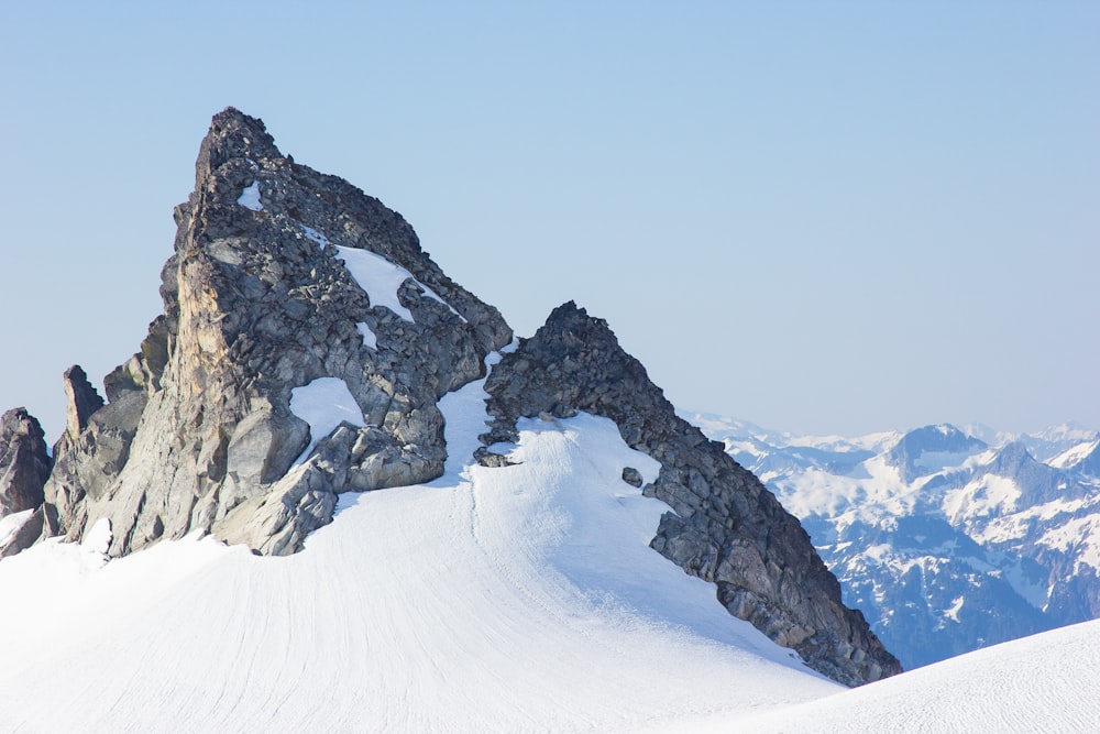 landscape shot of gray snowy mountain under blue sky