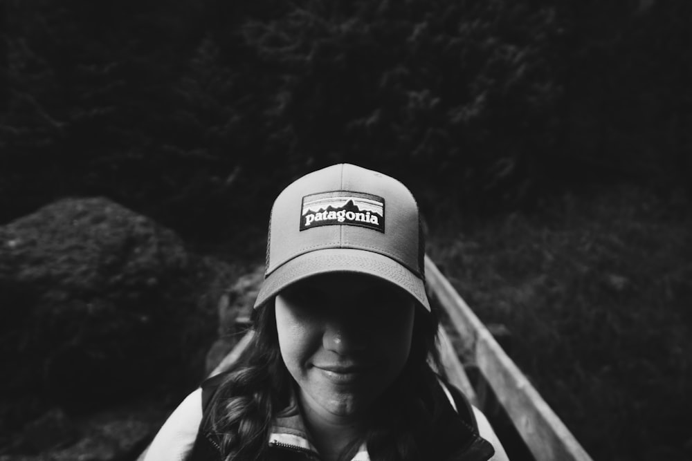 a black and white photo of a woman wearing a hat