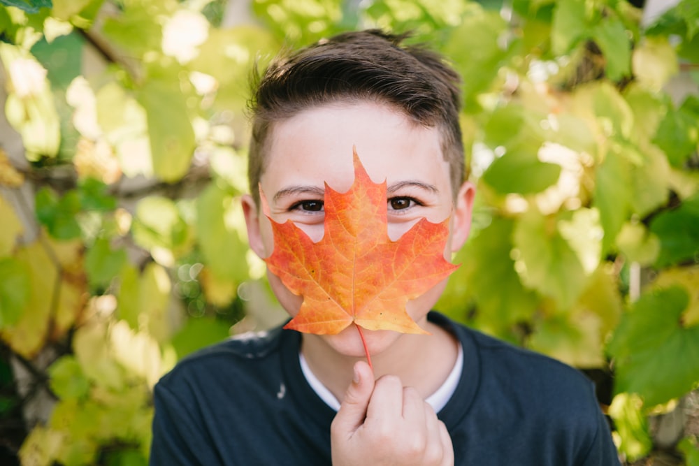 closeup photo of man covering his mount with leaf