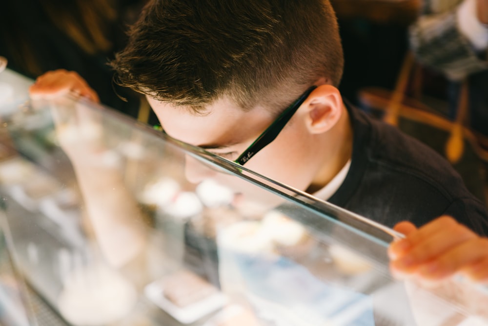 boy leaning on glass counter