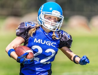 woman in blue helmet playing football