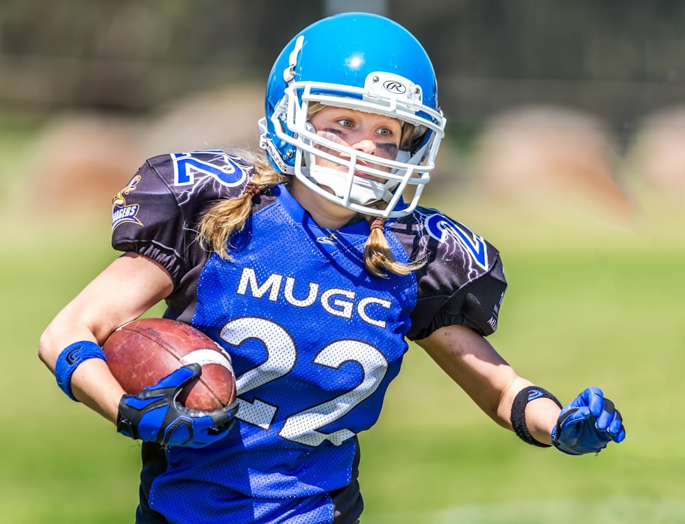 woman in blue helmet playing football