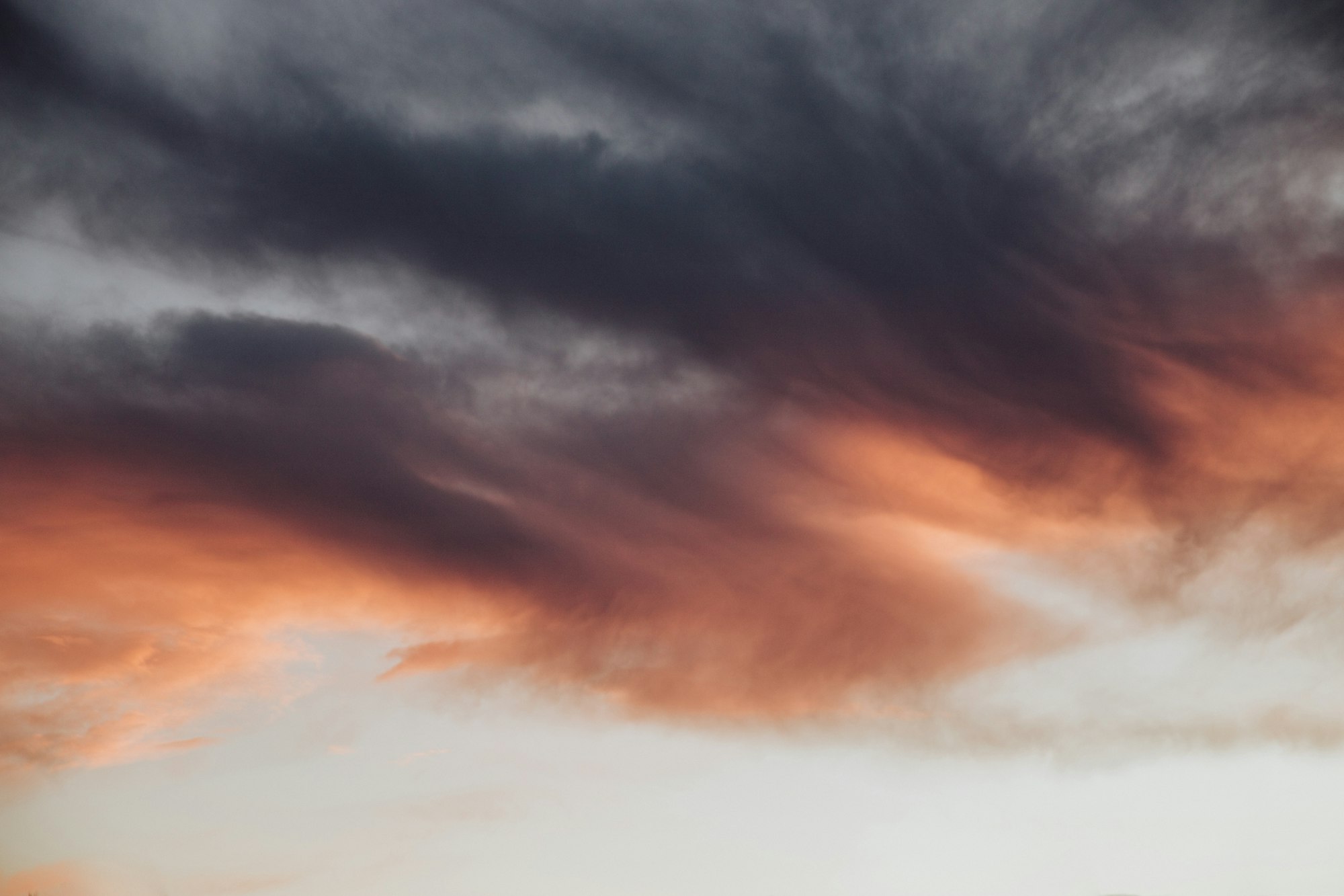 Pink and purple clouds in a light blue sky.