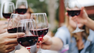 people tossing their clear wine glasses