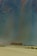 A group of people riding camels traverse across a vast desert landscape. The sand is marked by gentle dunes, and the sky above appears vast and expansive, possibly indicating a time of day when the sun is low. The scene conveys a sense of adventure and exploration.