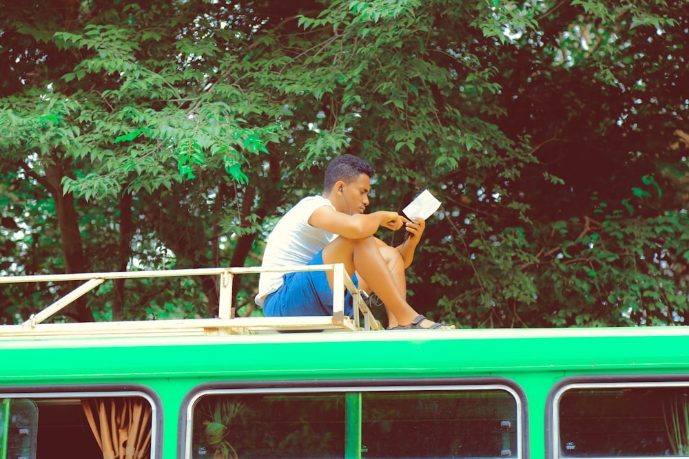 man reading notes on top of vehicle