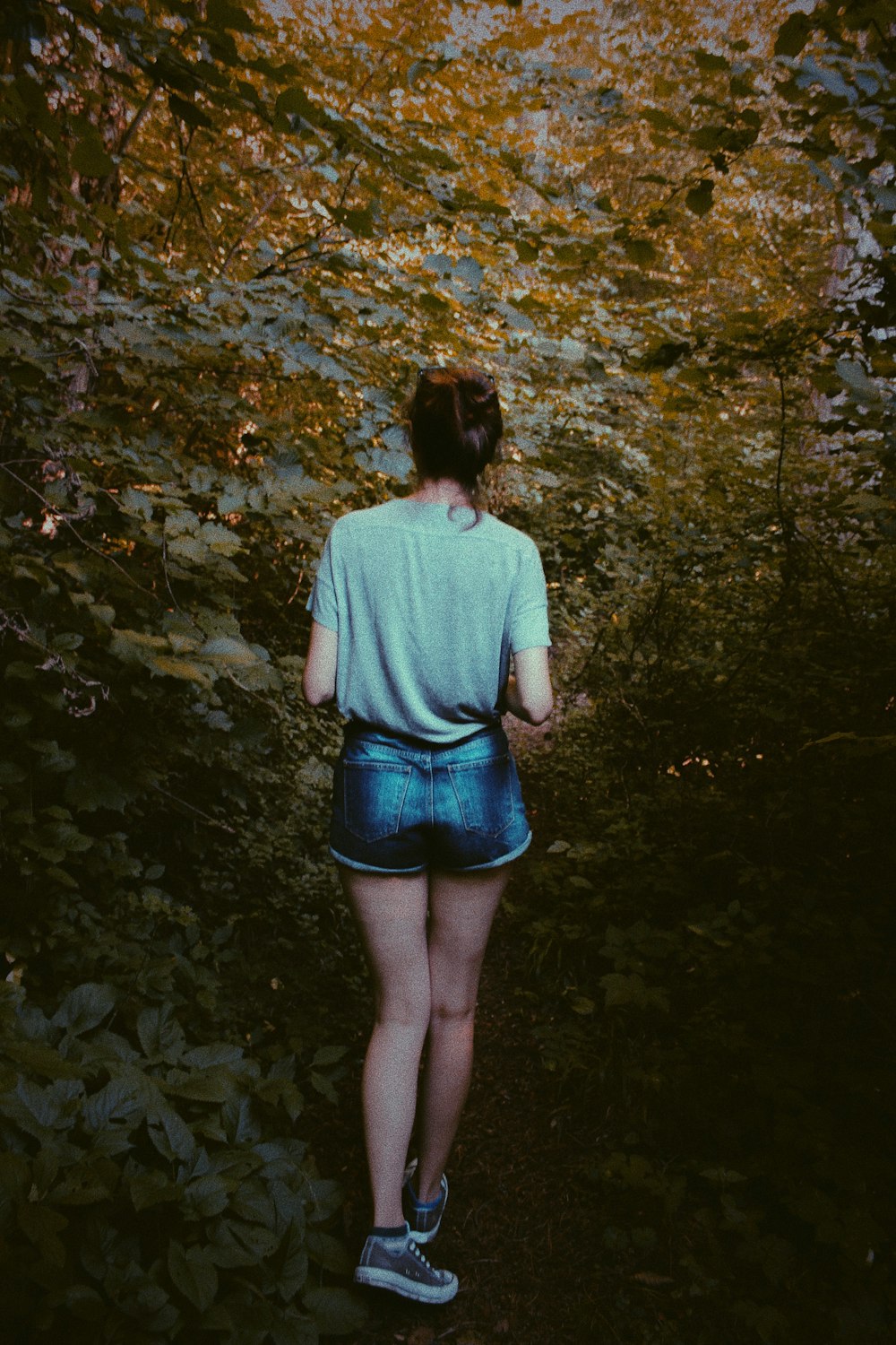 woman standing between trees