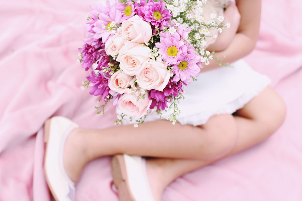 girl sitting on pink textile