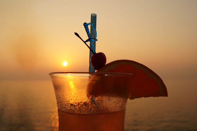 Couple enjoying a sunset cocktail on the Virgin Voyages sea terrace with the ocean stretching beyond.