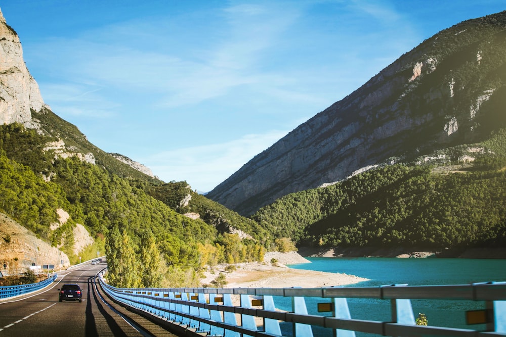 road near body of water and mountain