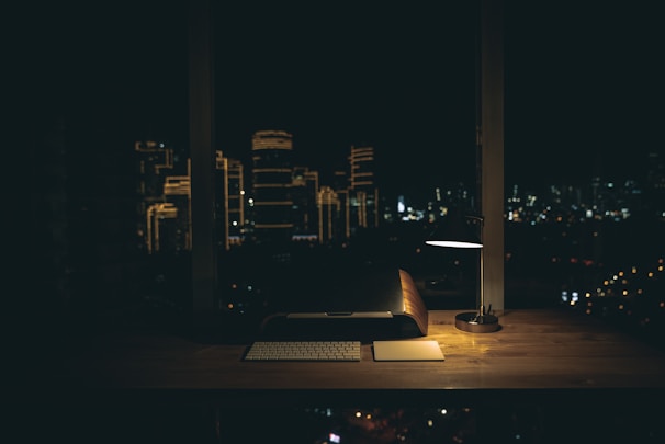 lit desk lamp on top of desk