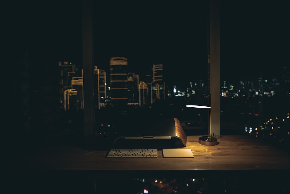 lit desk lamp on top of desk