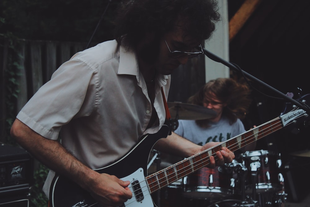 man playhing guitar beside man playing drums