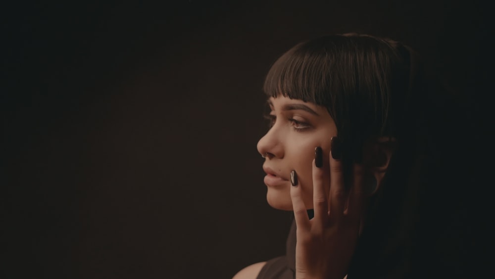 woman touch her cheek in dim light