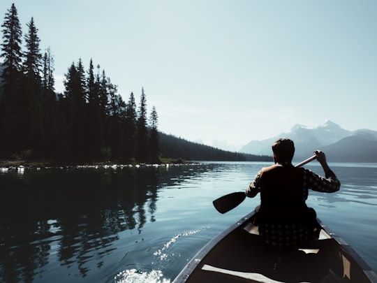 man on canoe sailing on the river in Maligne Lake Canada